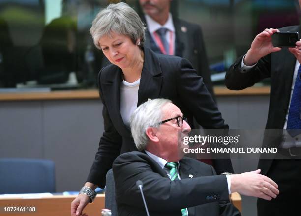 Britain's Prime Minister Theresa May walks behind President of the European Commission Jean-Claude Juncker as she arrives to attend a European Summit...