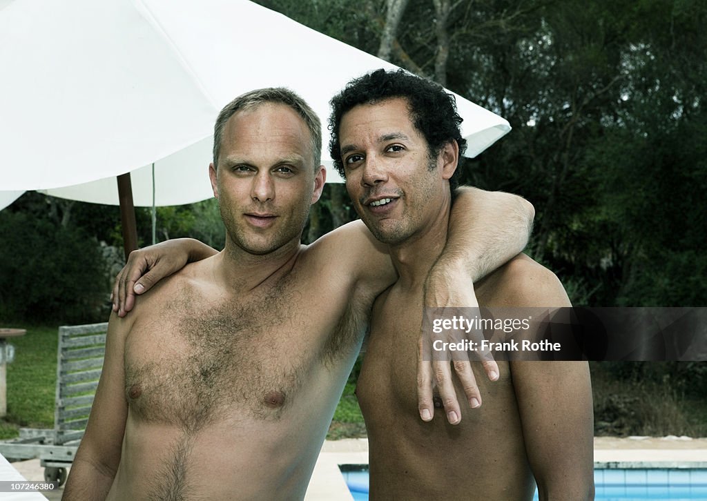 Two male friends by the swimming pool 