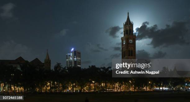 full moon and the rajabai clock tower in mumbai - mumbai market stock pictures, royalty-free photos & images