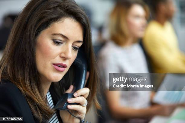 close-up of businesswoman talking on telephone - phone receiver stock pictures, royalty-free photos & images