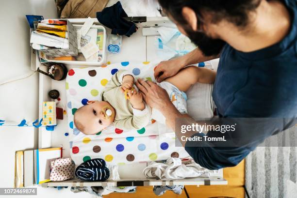 vater sein baby windel ändern - changing diaper stock-fotos und bilder