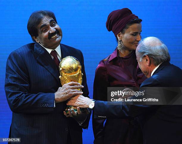 The Emir State of Qatar HH Sheikh Hamad bin Khalifa Al-Thani is presented with the World Cup Trophy by FIFA President Joseph S Blatter as Sheikha...