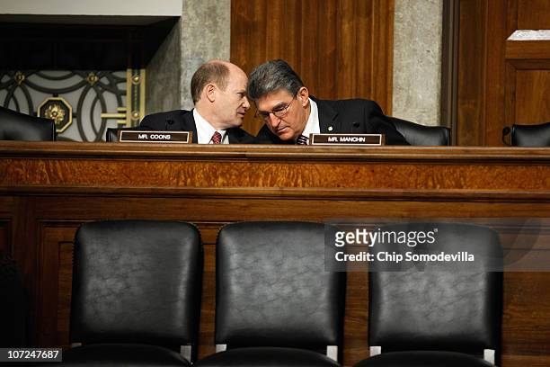 Senate Armed Services Committee members and freshmen Senators Chris Coons and Joe Manchin talk during a hearing about the military's "don't ask,...