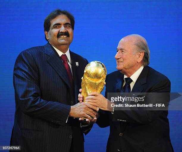 Sheikh Hamad bin Khalifa Al Thani receives the trophy from FIFA President Joseph S Blatter after the annoucement that Qatar had won the bid for the...
