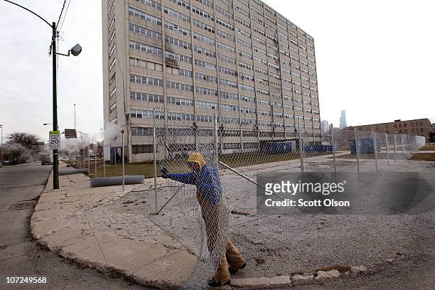 Charles Smith installs a fence around 1230 N. Burling St., the last occupied high-rise in the Cabrini-Green public housing complex on December 2,...
