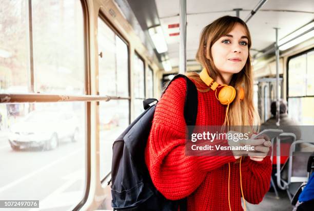 junge frau, die fahrt in öffentlichen verkehrsmitteln - nahverkehr stock-fotos und bilder