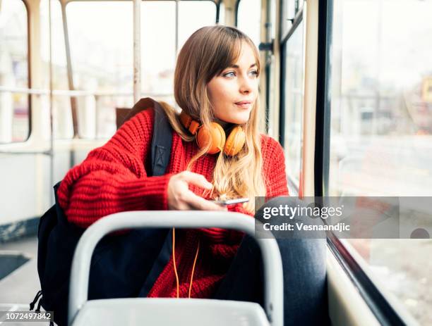 young woman riding in public transportation - young woman trolley stock pictures, royalty-free photos & images