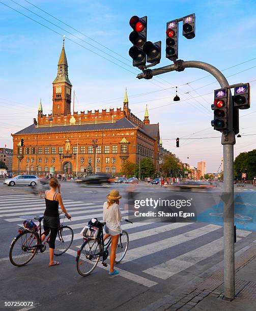 two woman on bikes in-front of town hall - copenhagen fotografías e imágenes de stock