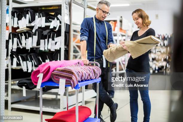 fashion industry workers discussing over the fabric - tailor pants stock pictures, royalty-free photos & images