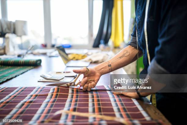 fashion designer cutting fabric at workbench - atelier mode stock-fotos und bilder