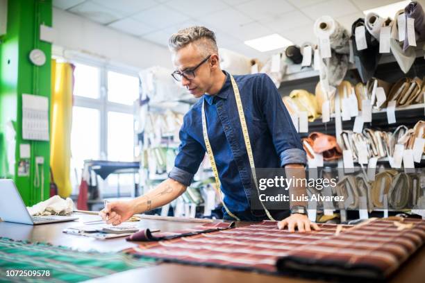 tailor working at his shop - area designer label - fotografias e filmes do acervo