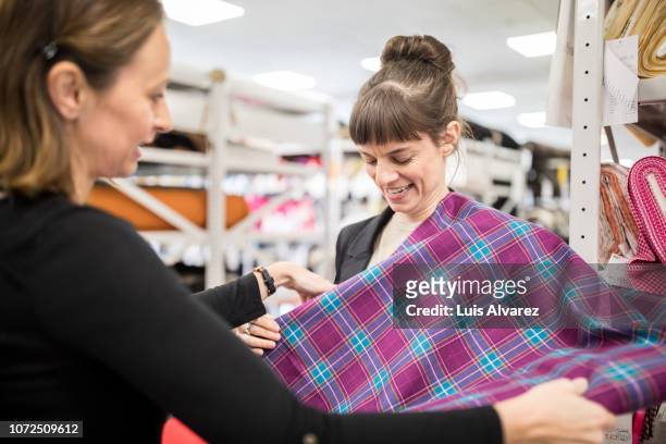 seamstress trying checkered fabric on customer - experience fashion and beauty day 2 stock-fotos und bilder