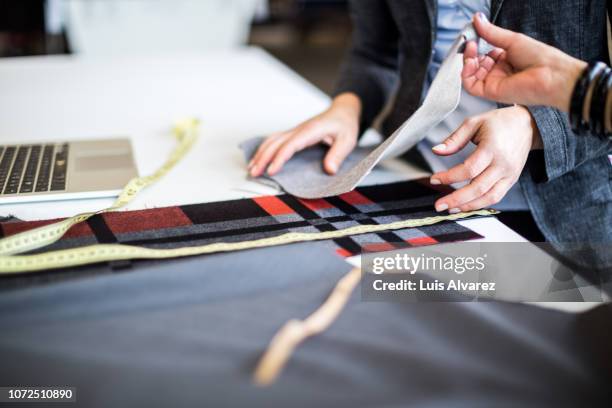 fashion designers discussing over fabric swatch at workbench - touching fabric stock pictures, royalty-free photos & images