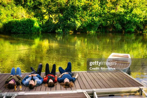 friends relaxing outdoors at the lake dock - party on the pier stock pictures, royalty-free photos & images