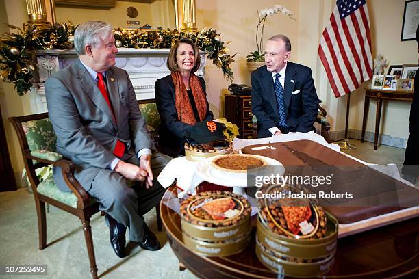 Speaker of the House Speaker Rep. Nancy Pelosi receives pecan pies from Rep. Joe Barton and a giant Hershey bar from Rep. Arlen Specter to settle a...