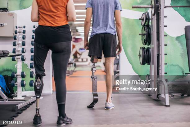 couple with prosthetic legs in gym - amputee rehab stock pictures, royalty-free photos & images