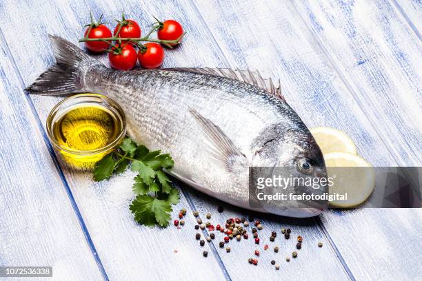 sea bream and ingredients for seasoning and cooking fish - sea bream stock pictures, royalty-free photos & images