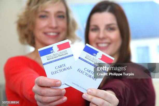 young women with voting cards - frankreich wahl stock-fotos und bilder
