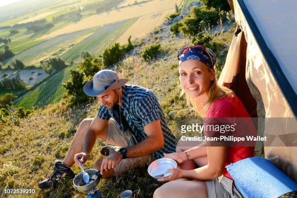 young couple in a tent camp on summer outdoor adventure hiking trip. - recreational pursuit photos et images de collection