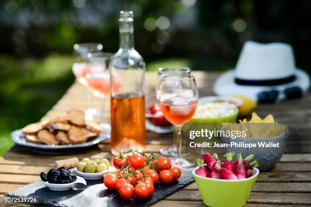 holiday summer brunch party table outdoor in house backyard with appetizer, glass of rose wine, fresh drink and organic vegetables. - table aperitif stock pictures, royalty-free photos & images