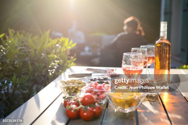 holiday summer brunch party table outdoor in house backyard with appetizer, glass of rose wine, fresh drink and organic vegetables. - aperitif stockfoto's en -beelden