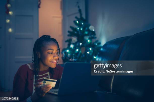 african women shopping christmas presents online at home - christmas budget stock pictures, royalty-free photos & images