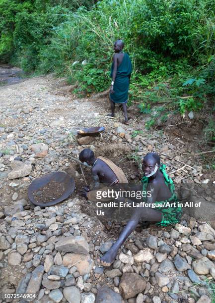 Suri tribe girls doing gold panning in a river, Omo valley, Kibish, Ethiopia on October 23, 2018 in Kibish, Ethiopia.