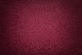Texture of old dark red paper background, closeup. Structure of dense cardboard.