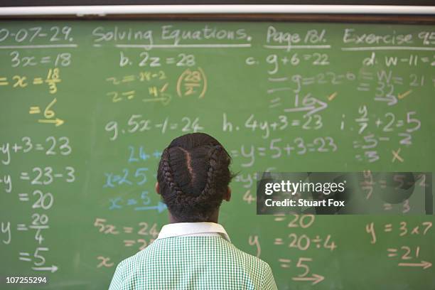 schoolgirl looking at chalkboard with algebra sums, kwazulu natal province, south africa - black fox stock pictures, royalty-free photos & images