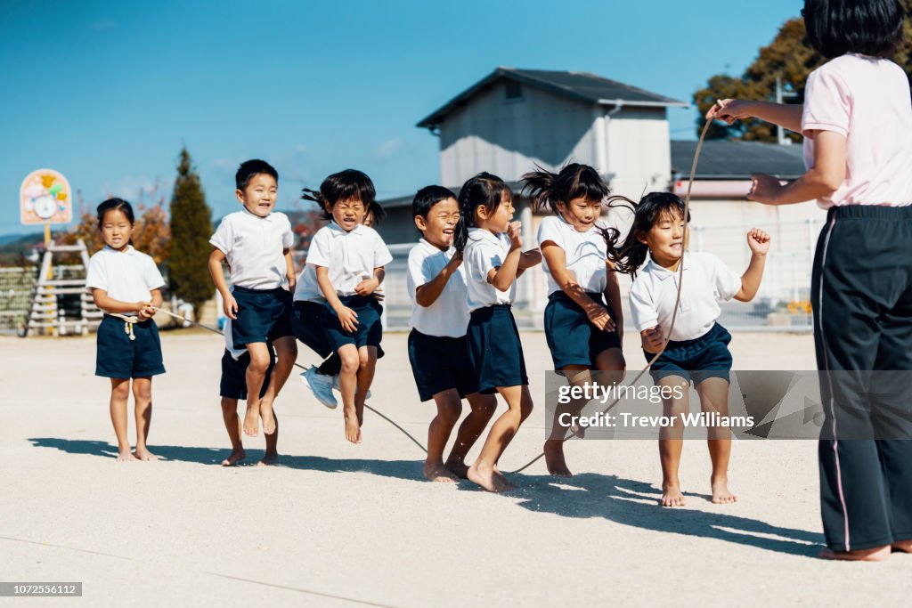Preschool aged children practicing with a jump rope with their teacher