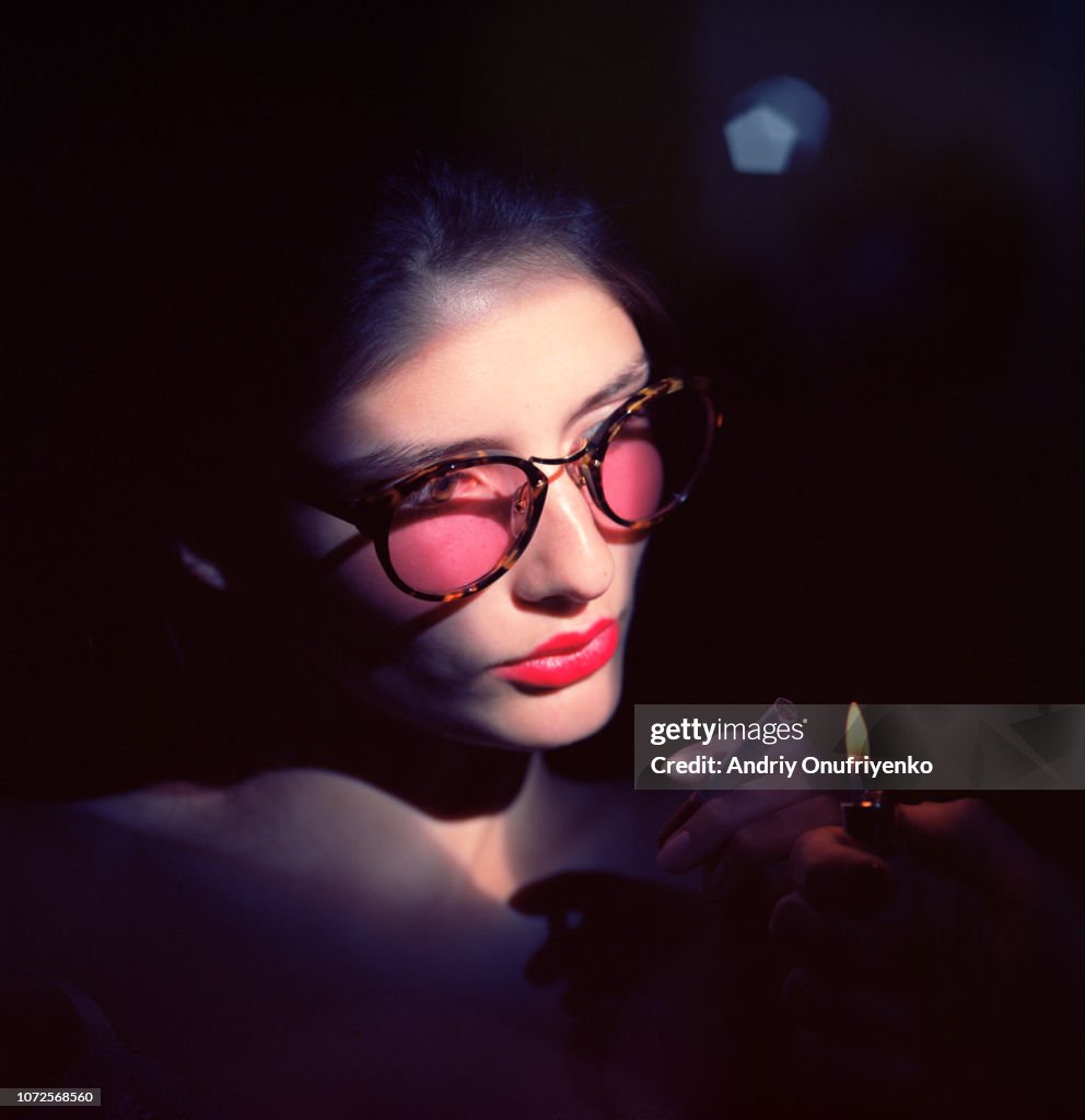Studio portrait of young woman wearing glasses