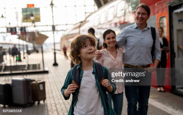 fröhlicher junge reisen mit dem zug mit seiner familie - depot stock-fotos und bilder