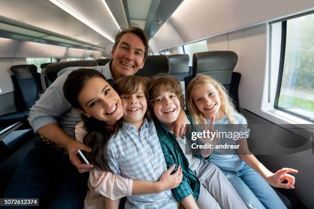 porträt einer sehr glücklichen familie reisen mit dem zug - familie in der bahn stock-fotos und bilder