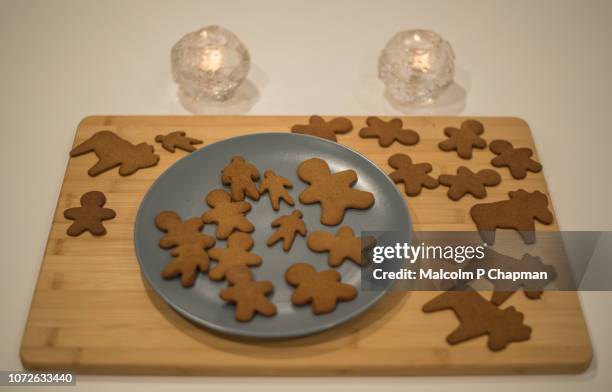 baked and cut gingerbread on a wooden board - swedish culture stock pictures, royalty-free photos & images