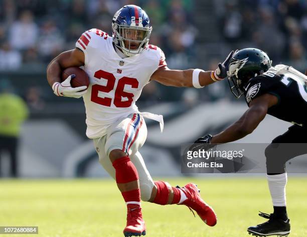 Saquon Barkley of the New York Giants carries the ball as he tries to avoid Corey Graham of the Philadelphia Eagles at Lincoln Financial Field on...