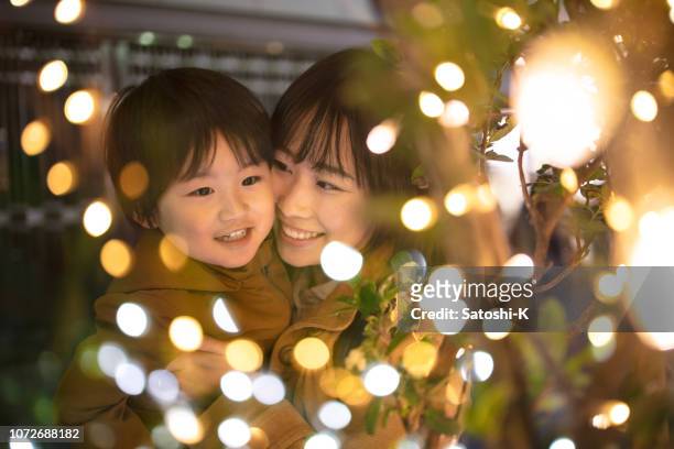 moeder en zoon genietend van kerstverlichting - asia kid stockfoto's en -beelden