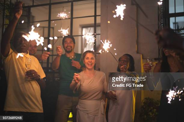 familie und freunde feiern silvesterparty mit wunderkerze zu hause - new year 2019 stock-fotos und bilder