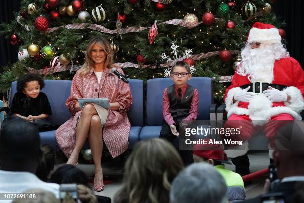 First lady Melania Trump reads aloud the story "Oliver the Ornament" to children patients as patient escorts Tearrianna Cooke-Starkey and Nathan Simm...