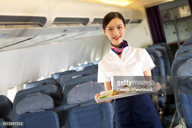 beautiful flight attendants - airplane tray stock-fotos und bilder