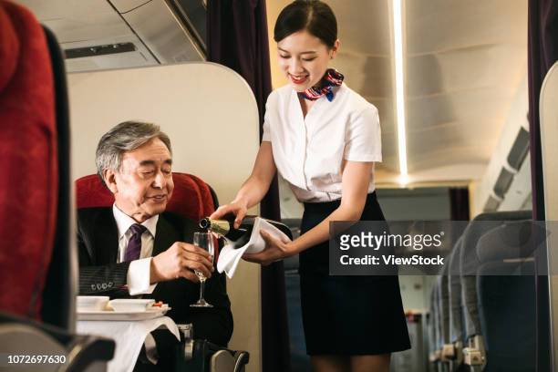 business people by plane - 客室乗務員 ストックフォトと画像