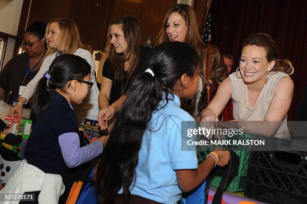 Singer and Actress Hilary Duff hands out food to school children during her appearance for the "Blessings in a Backpack" food program at the...