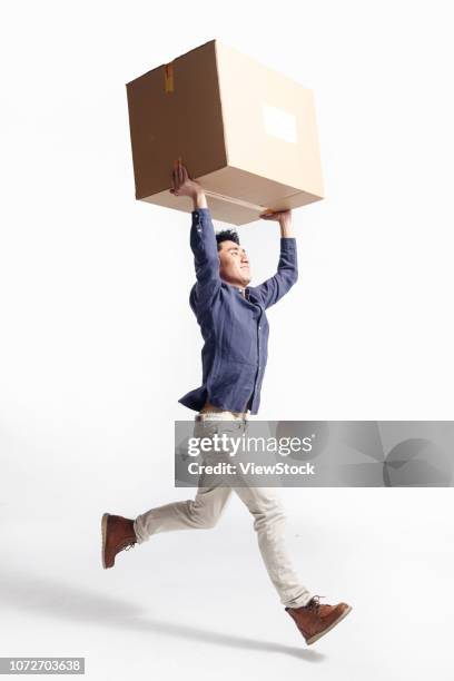 the young man carry the box - runstudio stock pictures, royalty-free photos & images