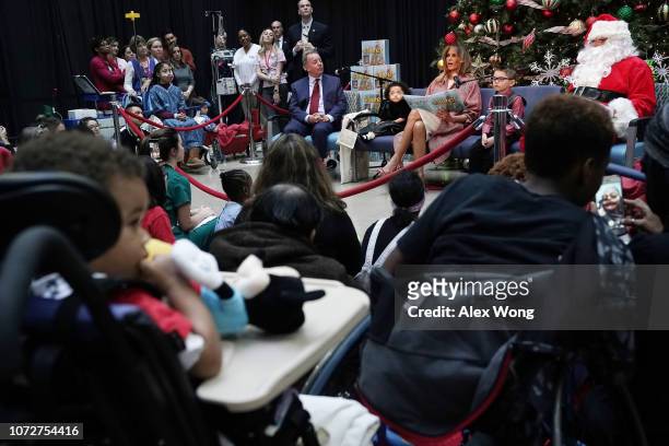 First lady Melania Trump reads the story "Oliver the Ornament" to children patients as author Todd Zimmerman, patient escorts Tearrianna...