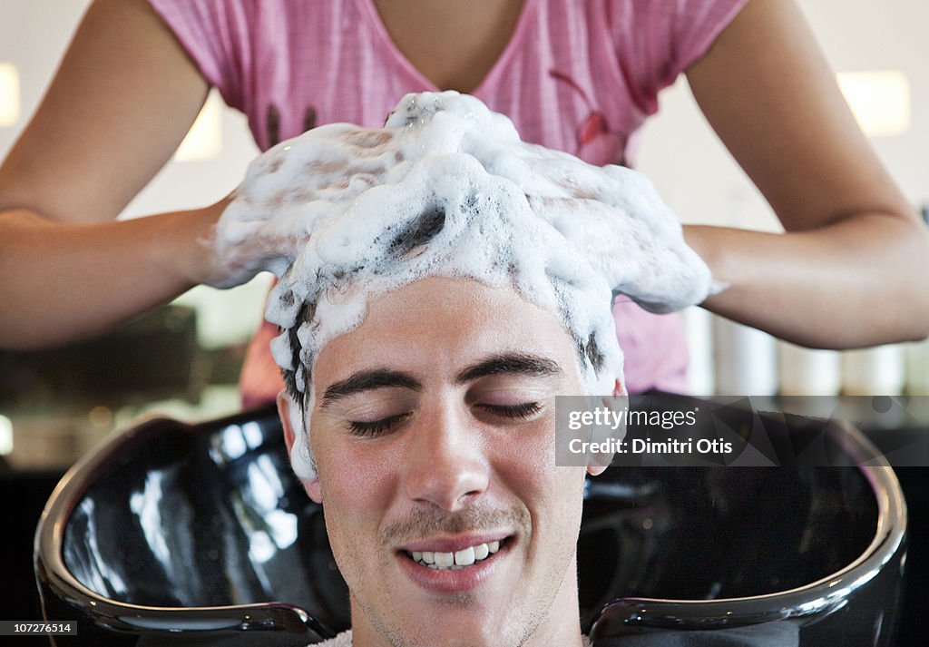 Man having his hair washed in hairdressing salon