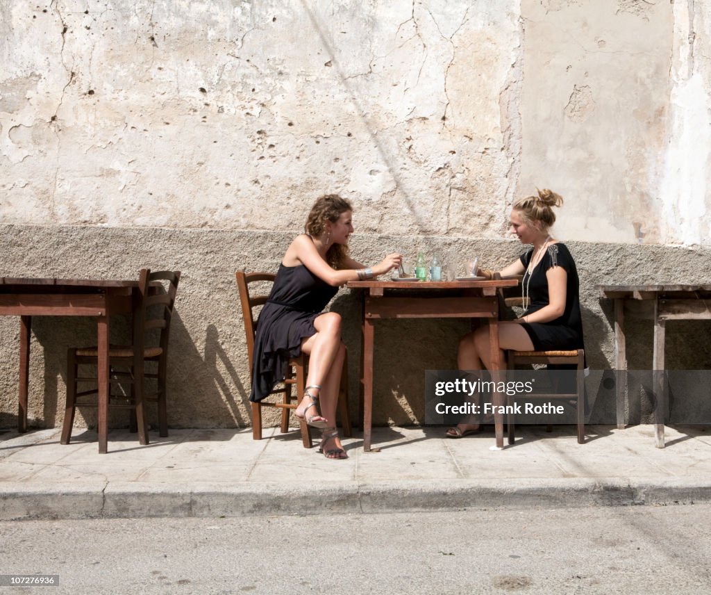 Two young woman having a coffee at a street cafe