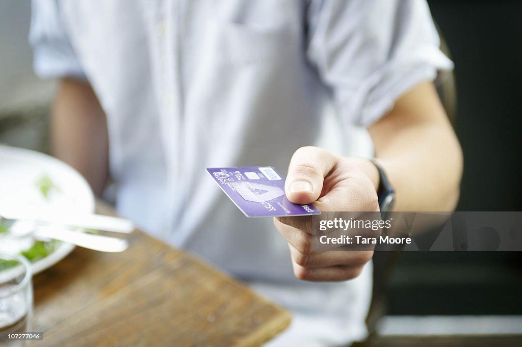 Hand with credit card in restaurant