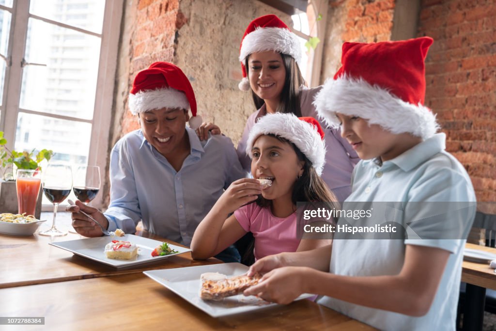 Familia feliz celebración de Navidad y comer postres