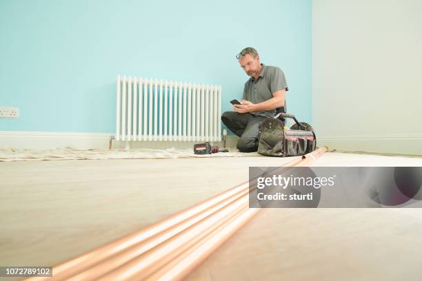 male plumber checking his book keeping - repairman phone stock pictures, royalty-free photos & images