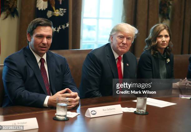 Florida Governor-elect Ron DeSantis sits next to U.S. President Donald Trump and Governor of South Dakota-elect Kristi Noem during a meeting with...