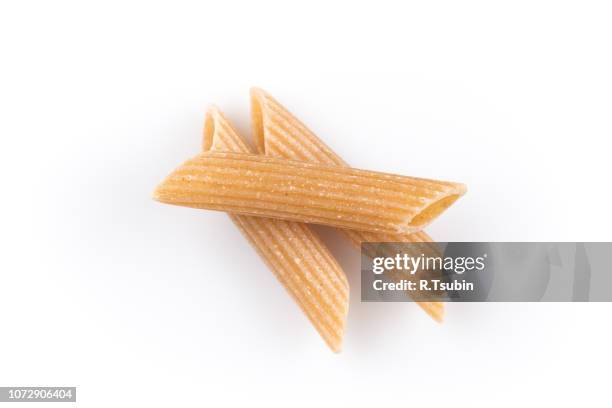 wholemeal pasta penne as close-up shot isolated on white background - whole wheat penne pasta stock pictures, royalty-free photos & images